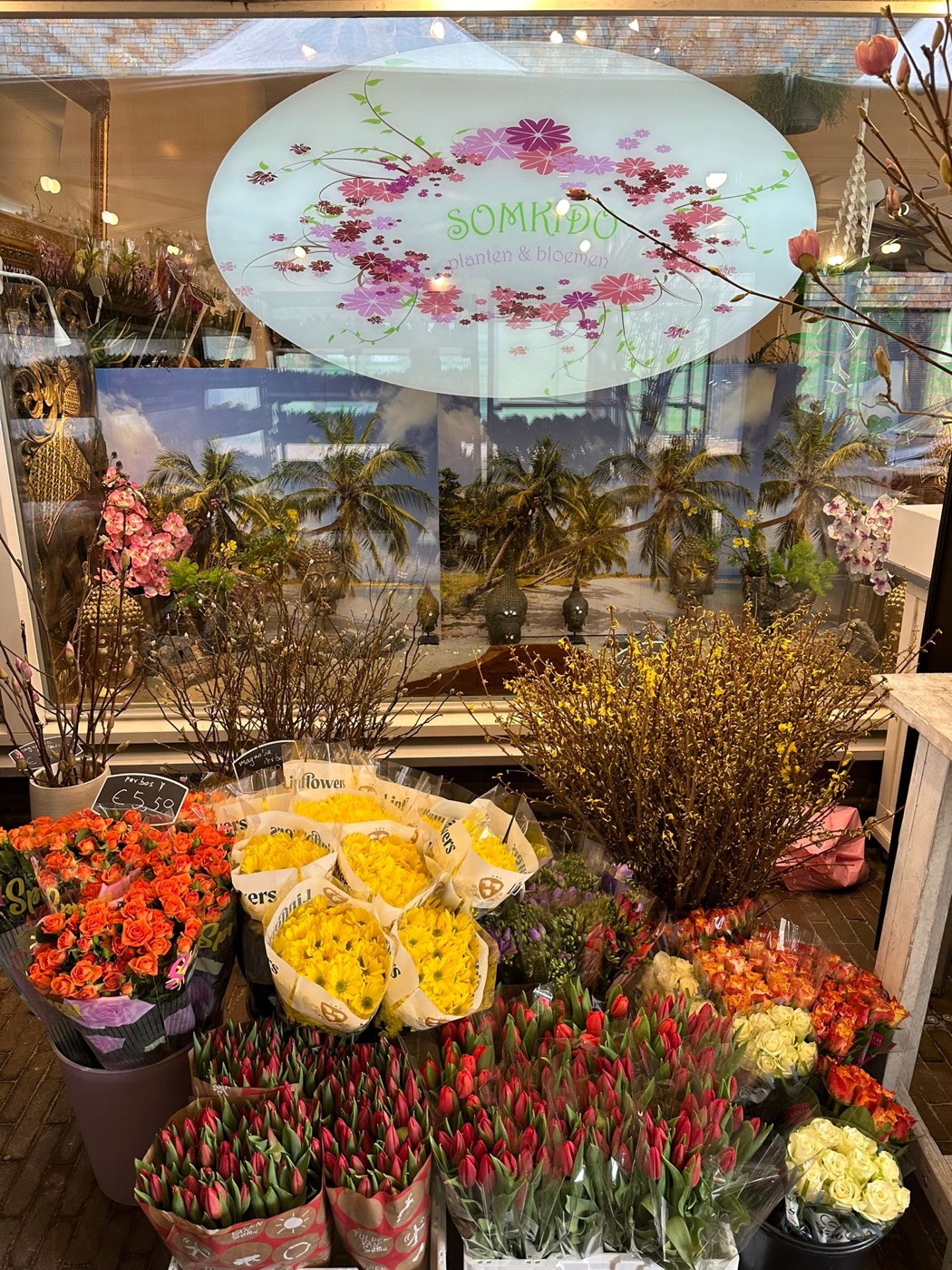 Volle bloemenwinkel van Somkido met emmers vol tulpen, rozen en seizoensbloemen